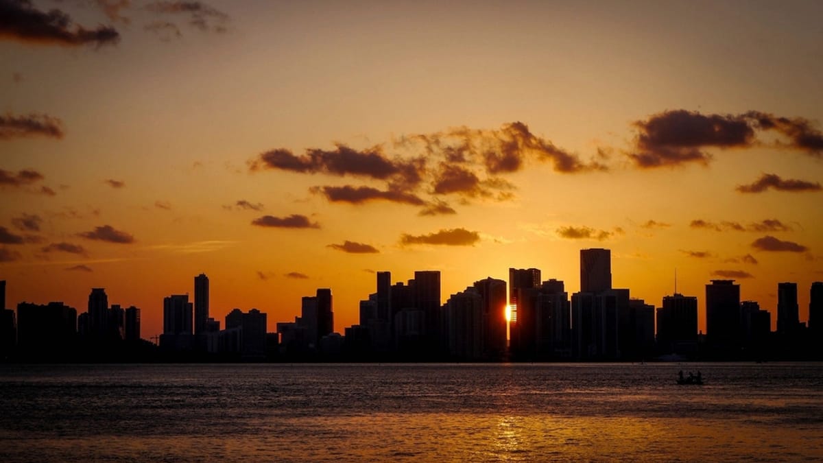 A coastal city skyline glowing at sunset