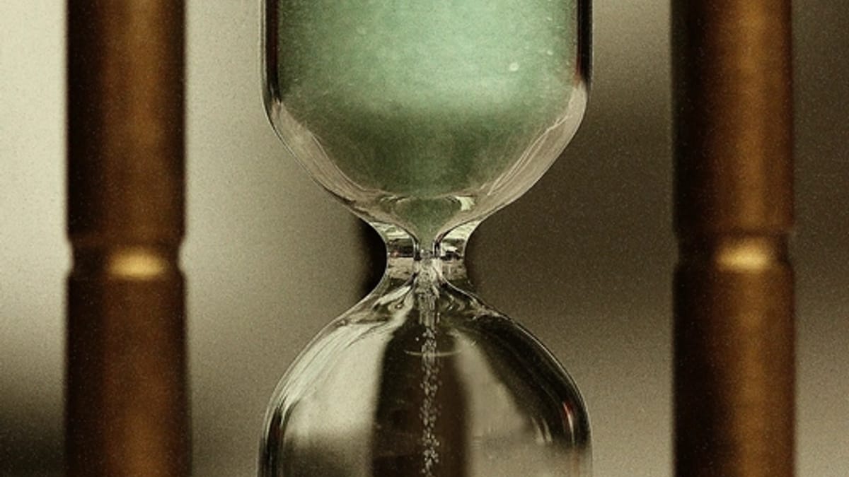 A glass hourglass with sand running through it